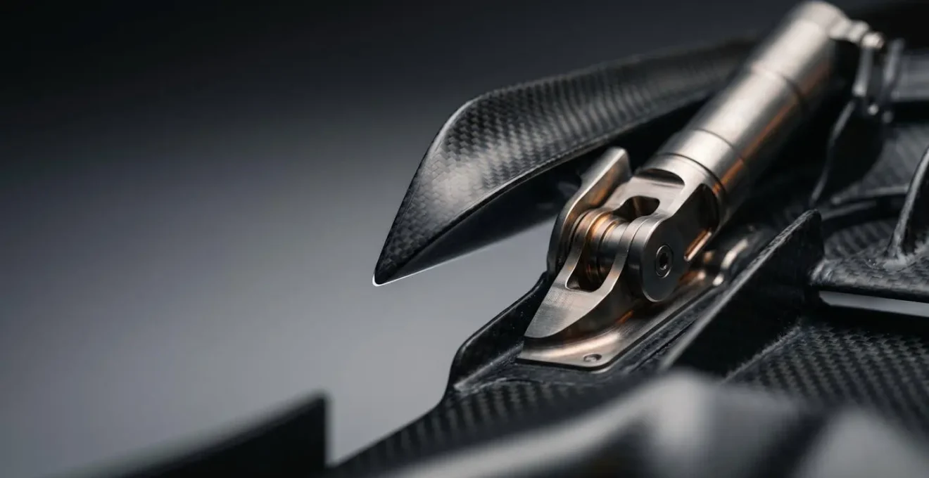 Close-up of Formula 1 rear wing DRS flap mechanism in dramatic lighting against clean background