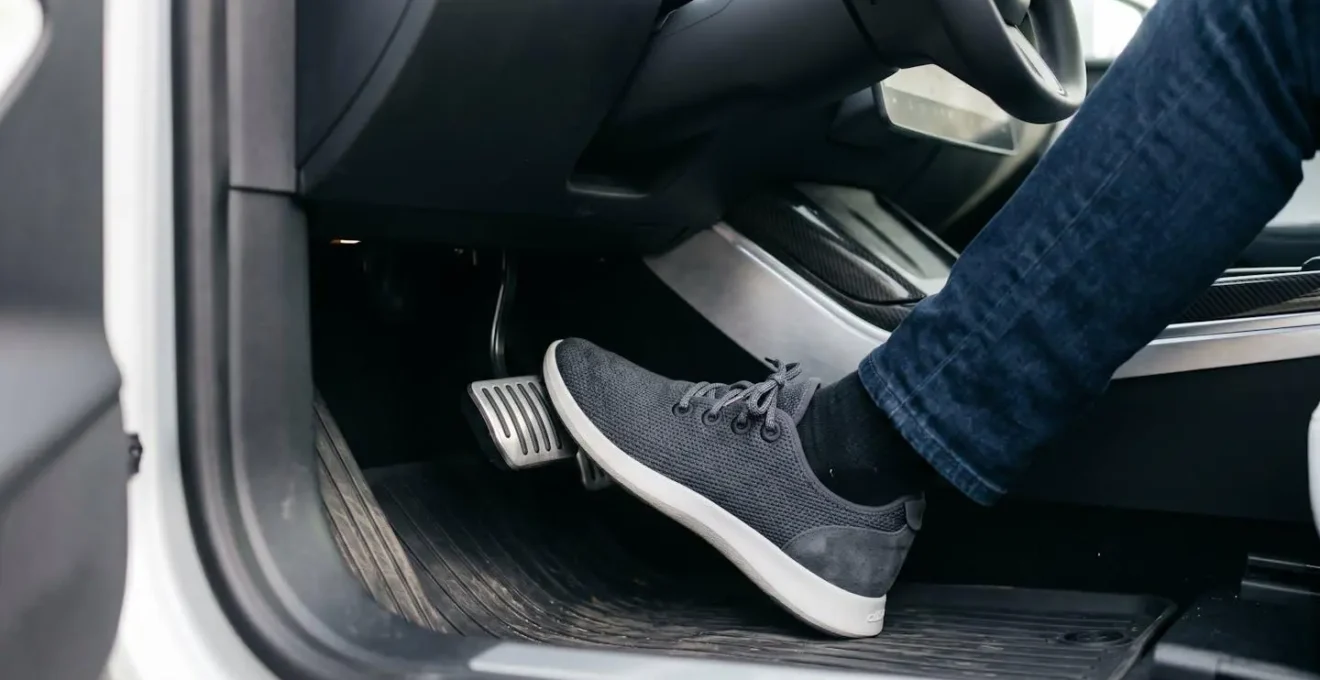 Close-up of driver's foot modulating electric vehicle accelerator pedal with smooth control, showcasing one-pedal driving technique