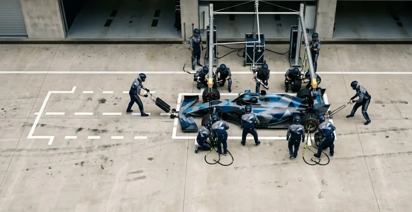Formula 1 racing car making precise pit stop maneuver with mechanics in motion capturing the strategic timing of the undercut